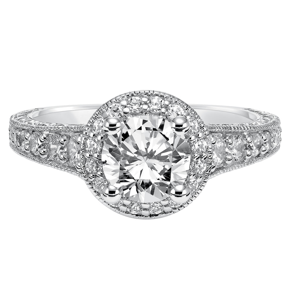 This show-stopping engagement ring is sure to impress with its diamond prong set halo and band with milgrain and engraving