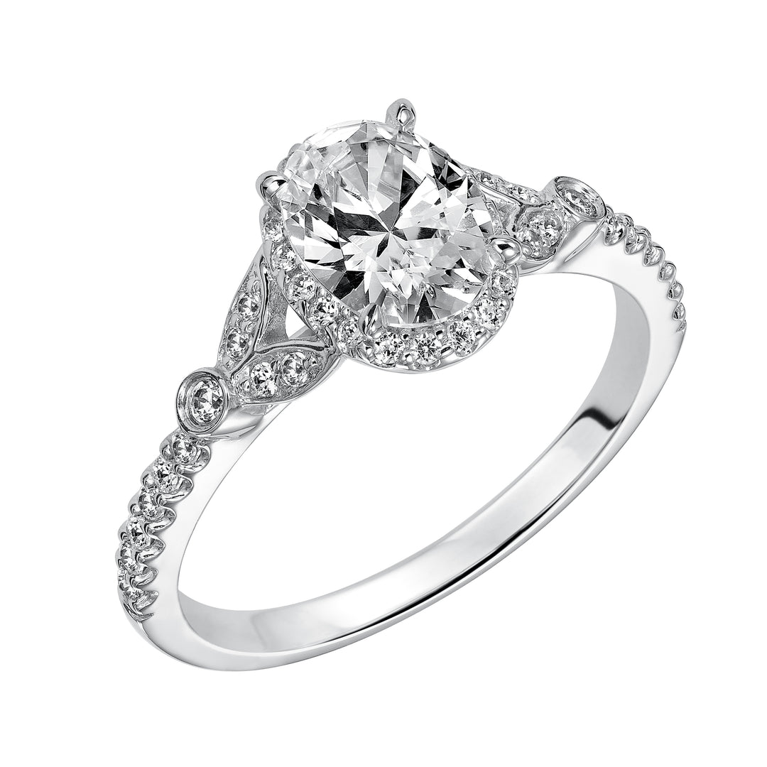 This romantic and beautiful engagement ring features an oval cut diamond accentuated by a prong set diamond halo and petal-inspired band design