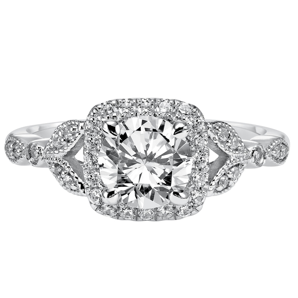 This whimsically styled engagement ring sparkles with its filigree and diamond halo and diamond prong set floral-inspired band