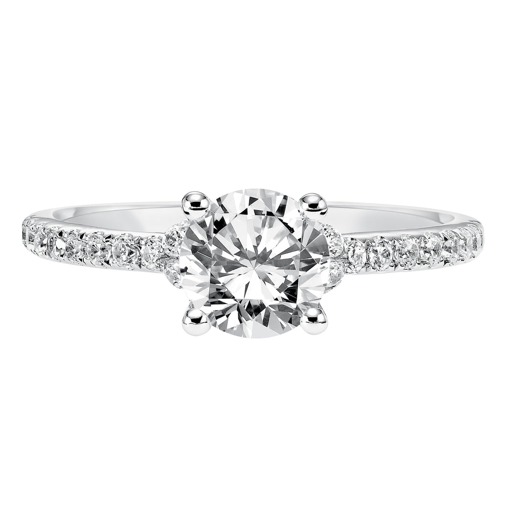 This engagement ring celebrates classic elegance with its delicate diamond prong set band and diamond tiara accent